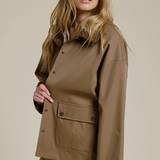 Woman wearing a brown jacket on a beige background