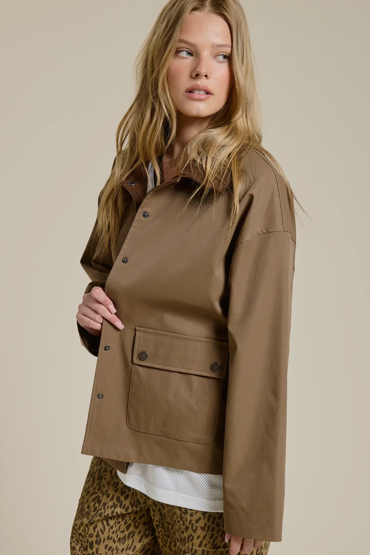 Woman wearing a brown jacket on a beige background