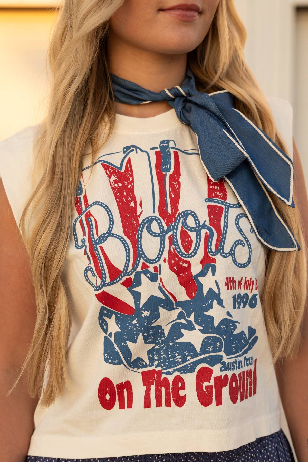 Person wearing a sleeveless top with 'Boots on the Ground' graphic design.