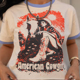 Person wearing a t-shirt with an 'American Cowgirl' graphic design.