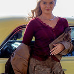 Woman standing next to a yellow car holding a brown jacket