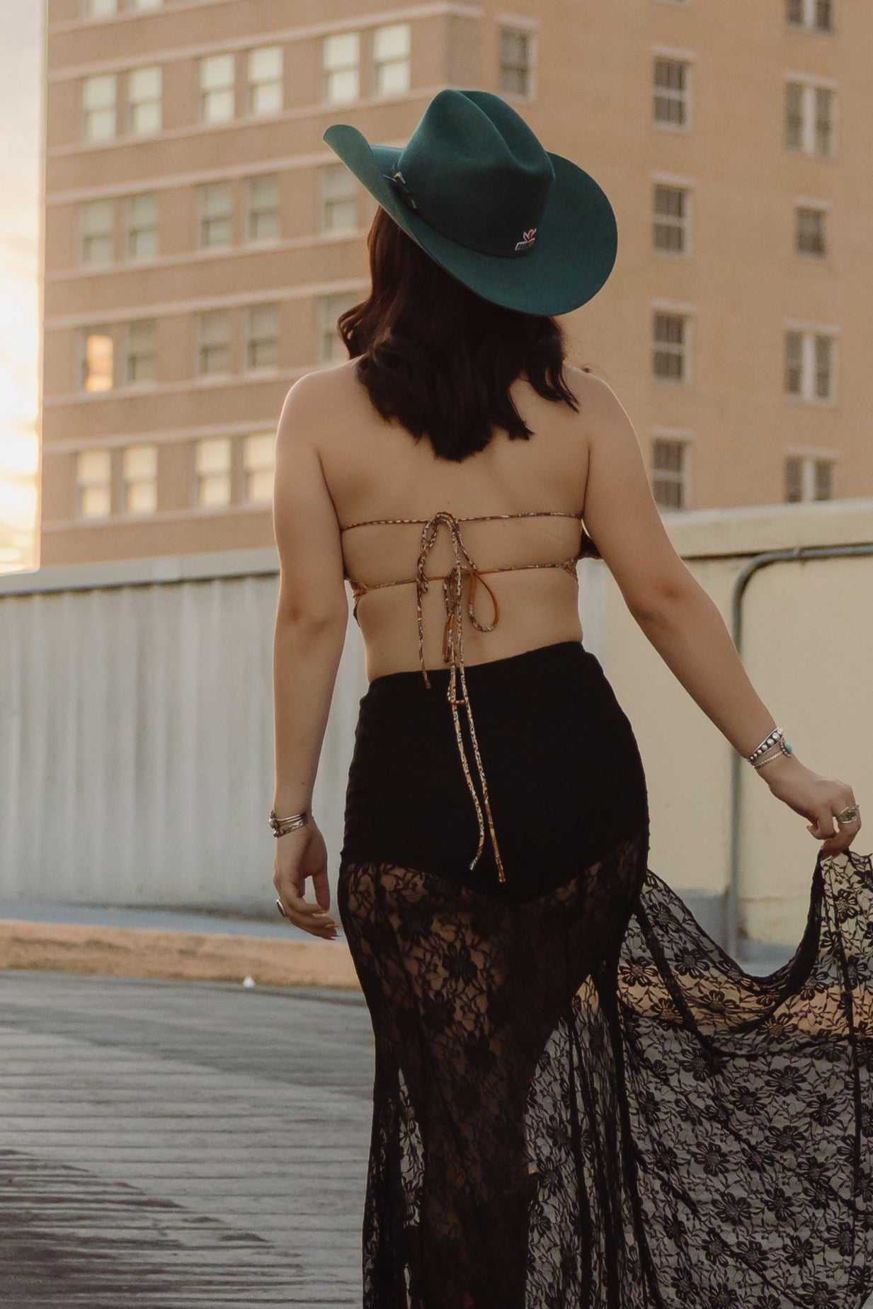 Woman on a rooftop with a building featuring 'ALICO' in the background
